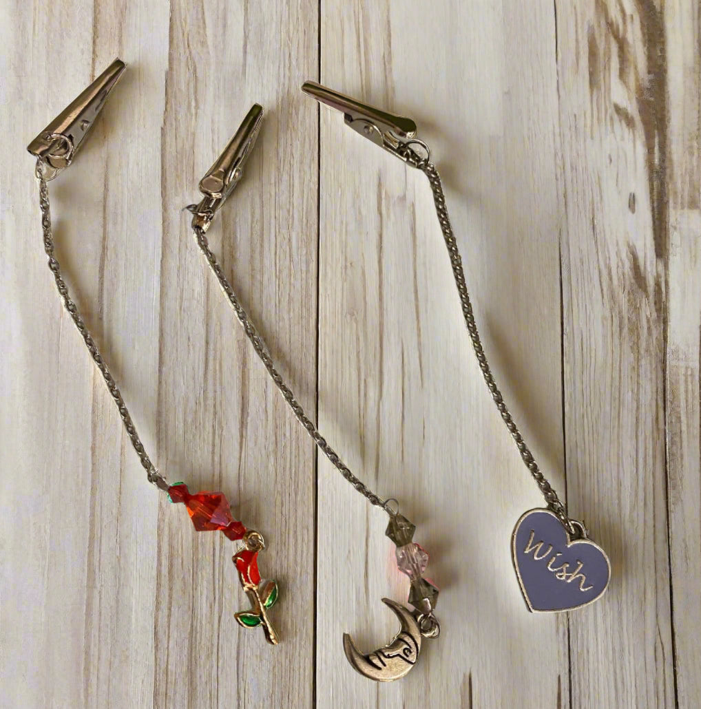 Tea Bag Leash with decorative charms on a light wooden surface