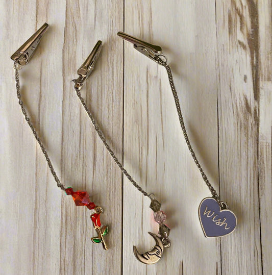 Tea Bag Leash with decorative charms on a light wooden surface