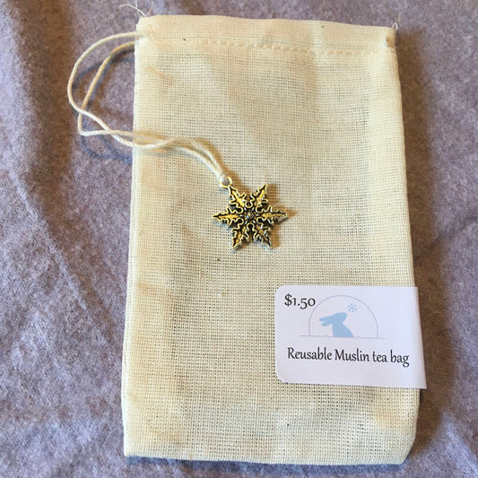 Reusable muslin tea bag with a decorative star charm and price tag on a textured surface